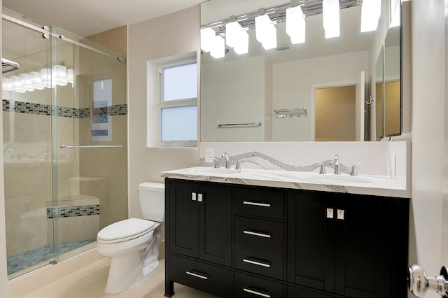bathroom featuring toilet, a stall shower, and a sink