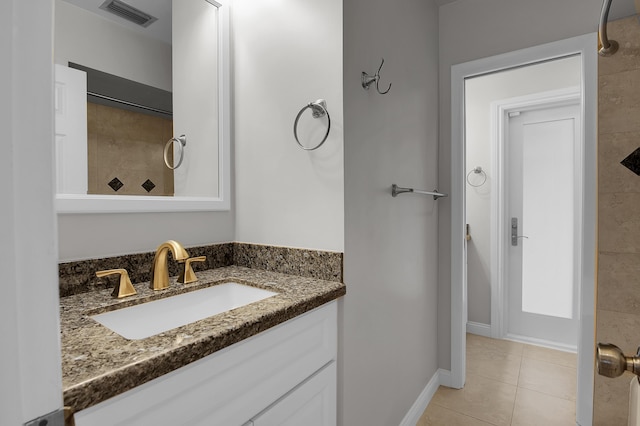 bathroom featuring tile patterned flooring, visible vents, vanity, baseboards, and tiled shower