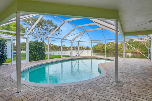 outdoor pool with a patio area, a lanai, and a water view