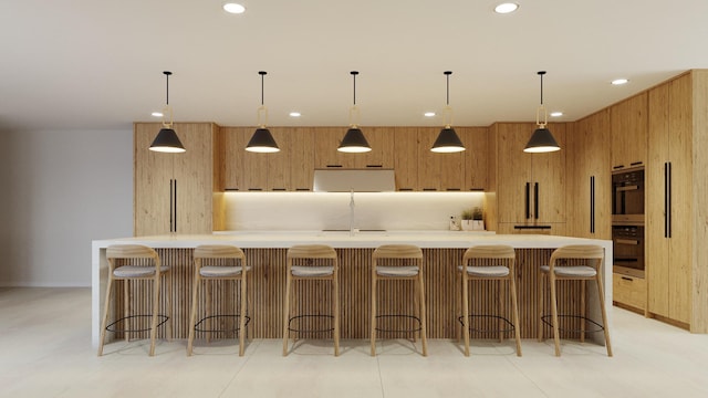 kitchen featuring recessed lighting, modern cabinets, brown cabinets, and a sink