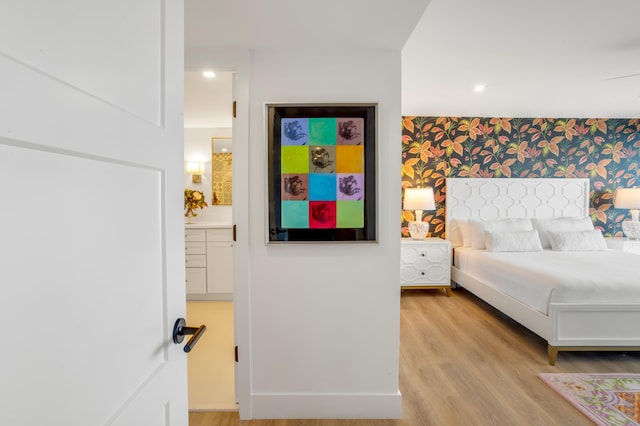 1180 S Ocean Blvd Unit 11D, Boca Raton, FL 33432 - bedroom with light wood-style floors, wallpapered walls, an accent wall, ensuite bath, and recessed lighting