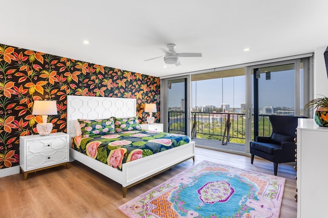 1180 S Ocean Blvd Unit 11D, Boca Raton, FL 33432 - bedroom with wallpapered walls, an accent wall, access to exterior, wood finished floors, and a ceiling fan