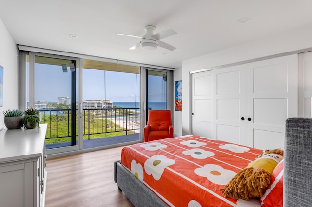 1180 S Ocean Blvd Unit 11D, Boca Raton, FL 33432 - bedroom featuring access to outside, a water view, light wood-type flooring, a wall of windows, and a closet