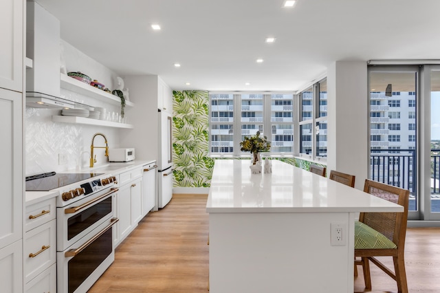 1180 S Ocean Blvd Unit 11D, Boca Raton, FL 33432 - kitchen featuring white appliances, a kitchen island, a sink, healthy amount of natural light, and recessed lighting
