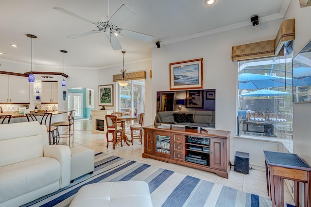 living area with ceiling fan, light tile patterned flooring, plenty of natural light, crown molding, and recessed lighting