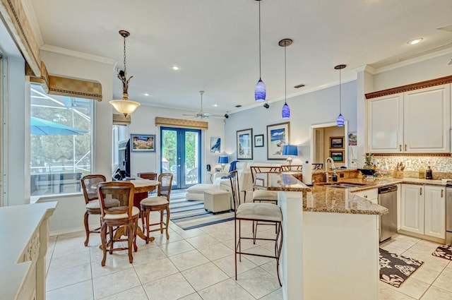 kitchen featuring a sink, light tile patterned floors, dishwasher, a peninsula, and decorative backsplash