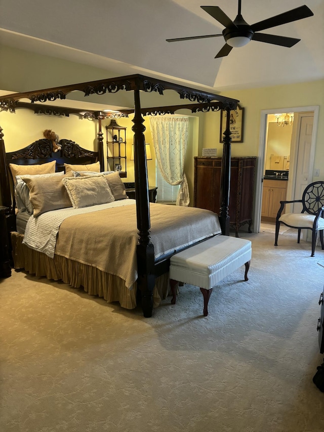 bedroom with carpet, lofted ceiling, a ceiling fan, and connected bathroom
