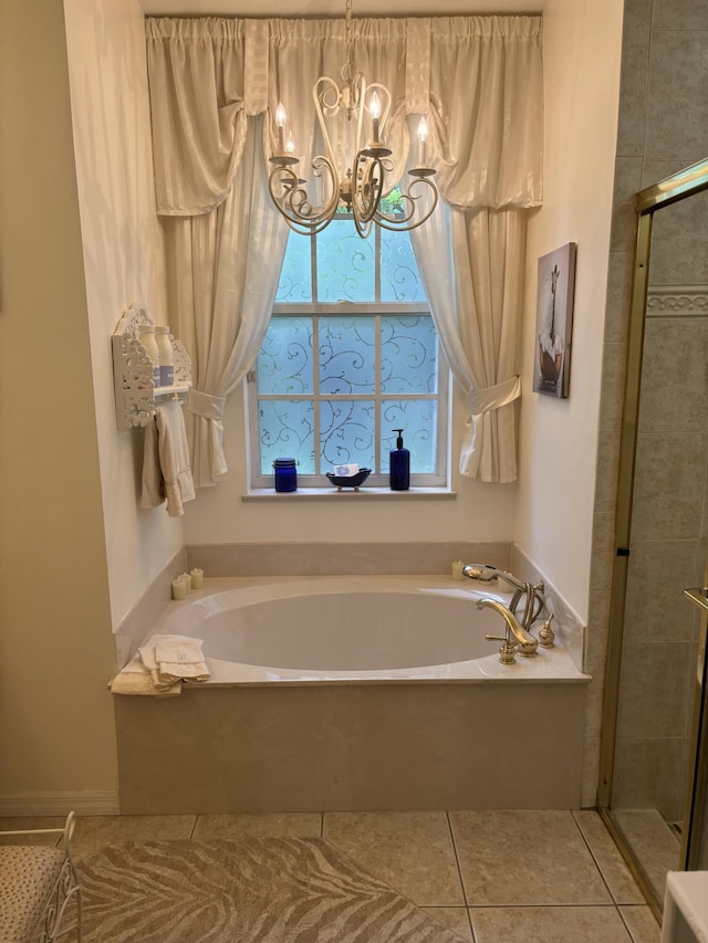 bathroom with tile patterned floors, a chandelier, a garden tub, and a stall shower