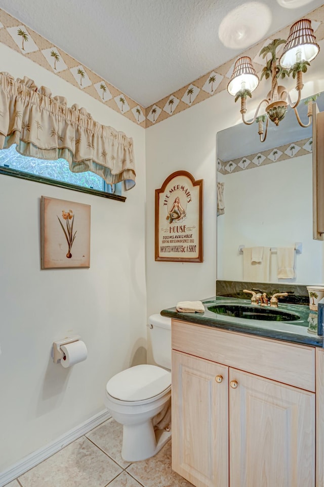 bathroom featuring toilet, vanity, tile patterned floors, a textured ceiling, and baseboards