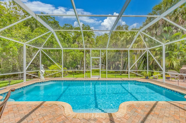 swimming pool featuring glass enclosure and a patio area