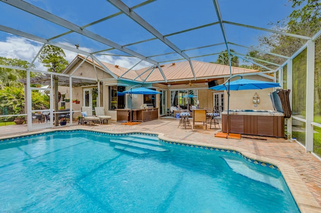 outdoor pool with a hot tub, a patio area, ceiling fan, and a lanai