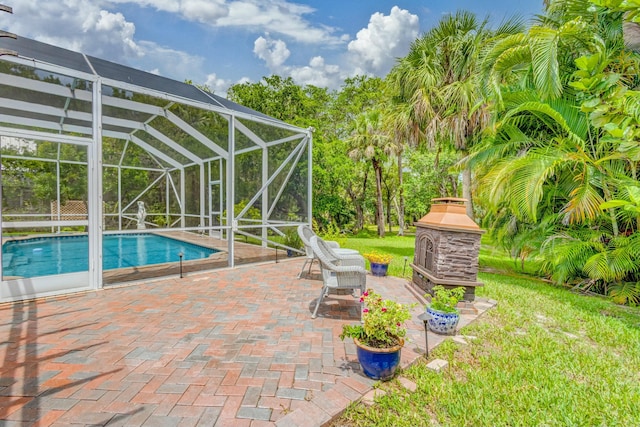 outdoor pool with a patio area, an outdoor stone fireplace, a lanai, and a yard