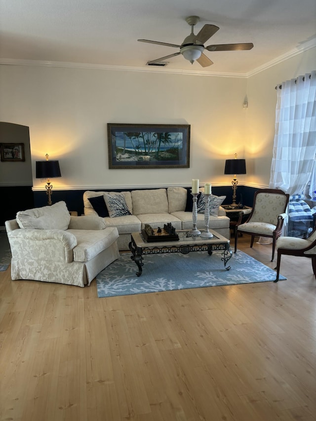 living room with crown molding, ceiling fan, and wood finished floors