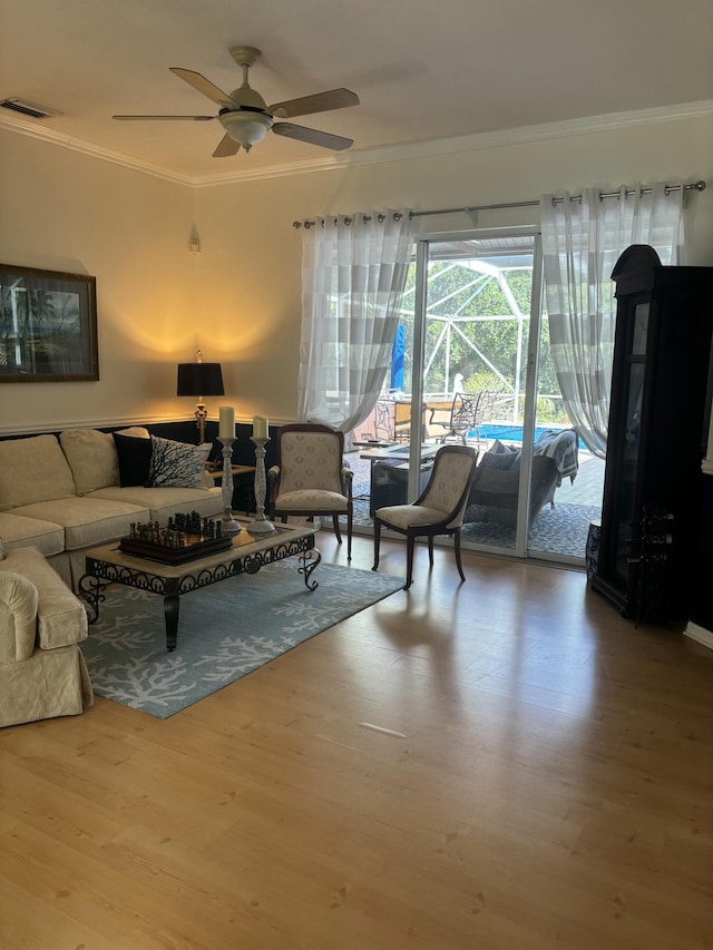 living room featuring ornamental molding, a ceiling fan, and wood finished floors