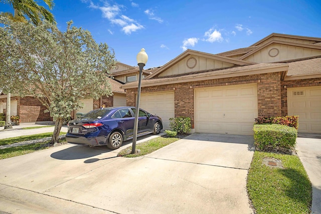 multi unit property with concrete driveway, brick siding, and a garage