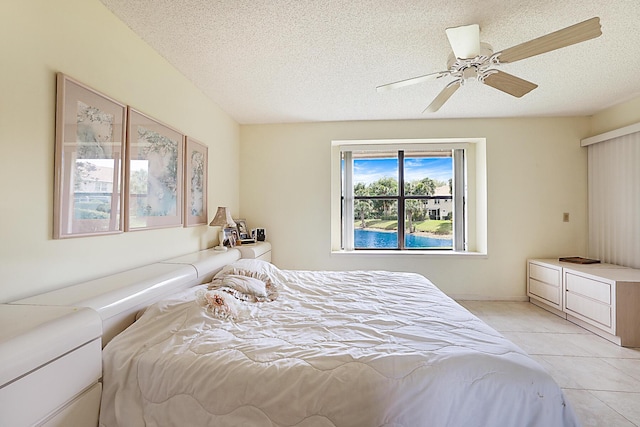bedroom with light tile patterned floors, a textured ceiling, and ceiling fan