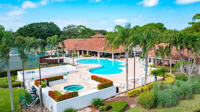 pool with a patio area, fence private yard, and a hot tub