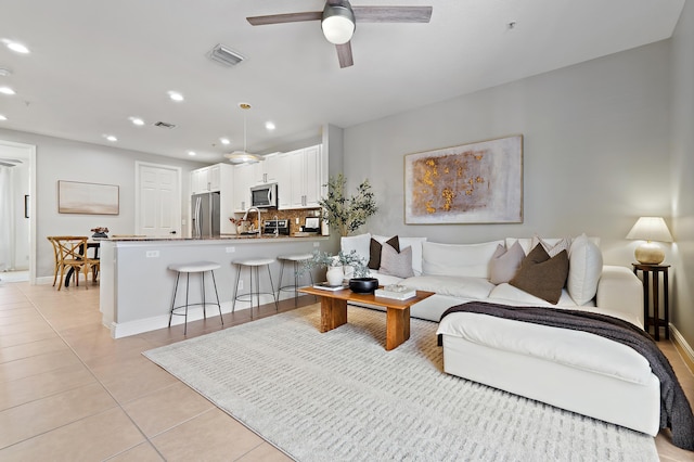 living room featuring light tile patterned floors, ceiling fan, visible vents, and recessed lighting