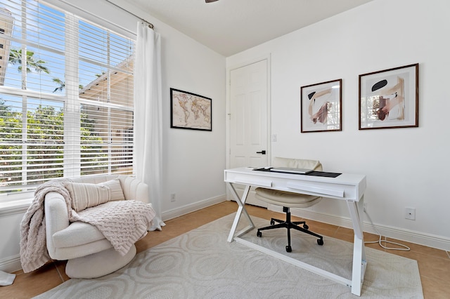 office area with a wealth of natural light, light tile patterned flooring, and baseboards