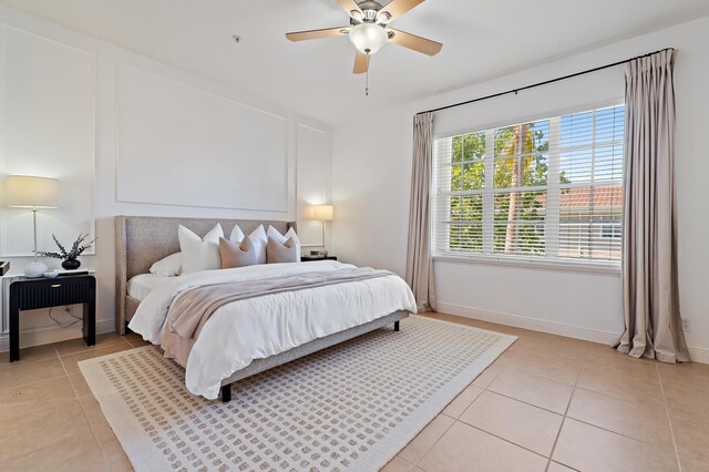 bedroom with light tile patterned floors, baseboards, and ceiling fan