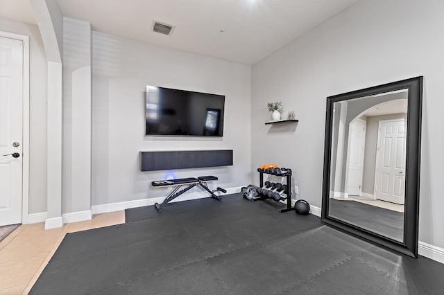exercise room featuring visible vents, baseboards, and arched walkways