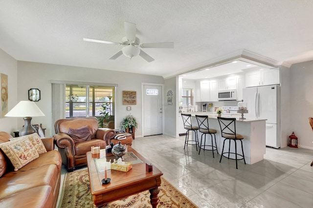 815 Club Dr Unit D, Delray Beach, FL 33445 - living room with a ceiling fan, baseboards, and a textured ceiling