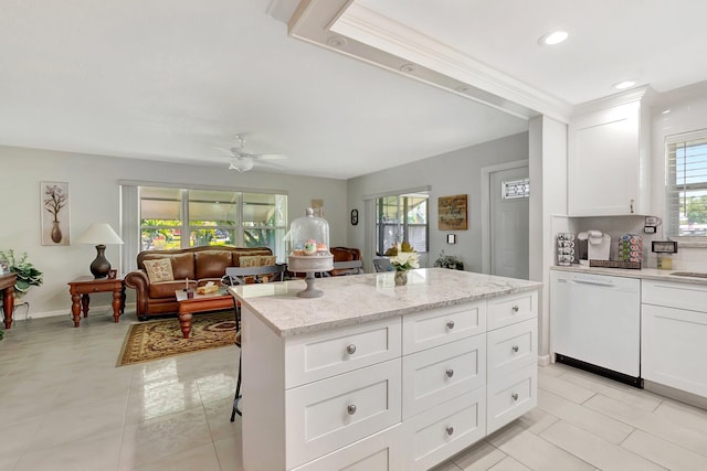 815 Club Dr Unit D, Delray Beach, FL 33445 - kitchen featuring white dishwasher, a ceiling fan, a center island, light stone countertops, and white cabinetry