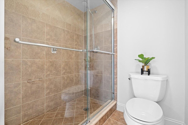 1811 SW Palm City Rd Unit A-202, Stuart, FL 34994 - bathroom featuring a stall shower, toilet, baseboards, and tile patterned floors