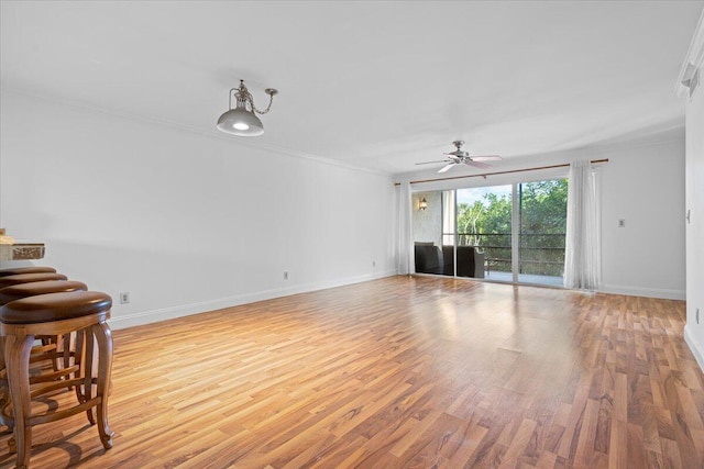 1811 SW Palm City Rd Unit A-202, Stuart, FL 34994 - unfurnished living room featuring ornamental molding, ceiling fan, light wood finished floors, and baseboards