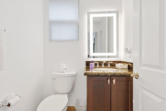 half bathroom featuring toilet and vanity