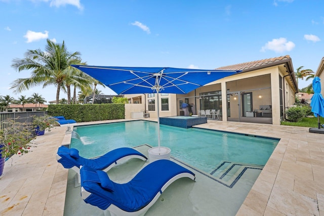 view of pool with a patio, fence, and a pool with connected hot tub