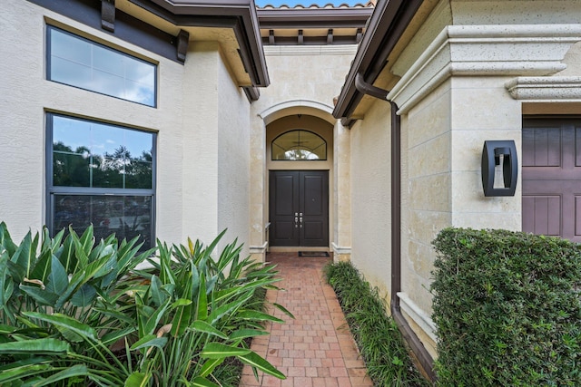 view of exterior entry with stucco siding and stone siding