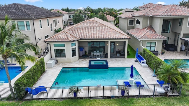 rear view of property featuring a tiled roof, a fenced backyard, stucco siding, a patio area, and a pool with connected hot tub
