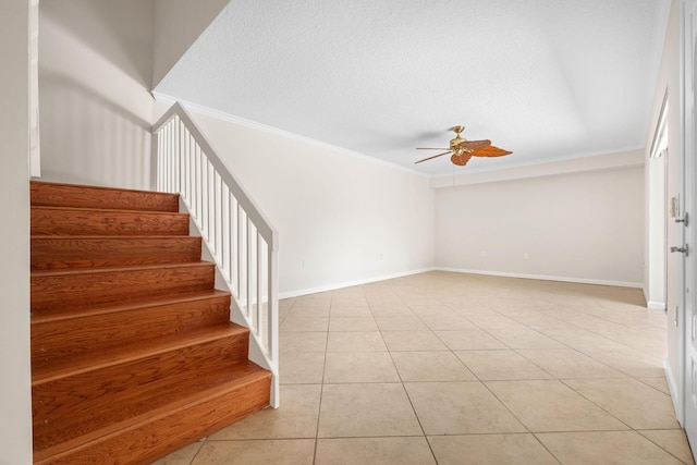 staircase with tile patterned flooring, baseboards, a ceiling fan, and crown molding
