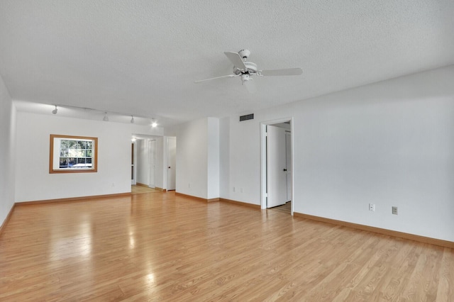 1852 SW Palm City Rd Unit 202, Stuart, FL 34994 - empty room featuring track lighting, a ceiling fan, light wood-style flooring, and a textured ceiling