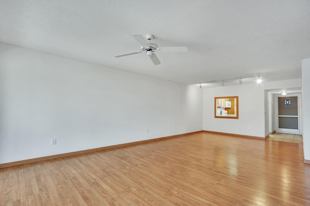 1852 SW Palm City Rd Unit 202, Stuart, FL 34994 - unfurnished room featuring light wood-type flooring, rail lighting, a ceiling fan, and a textured ceiling