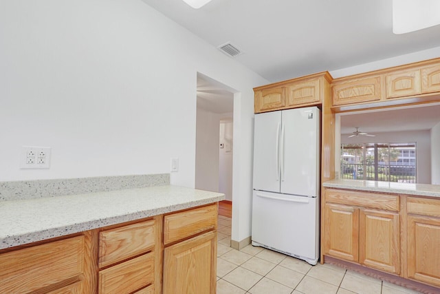1852 SW Palm City Rd Unit 202, Stuart, FL 34994 - kitchen with freestanding refrigerator, light tile patterned flooring, light brown cabinets, and a ceiling fan