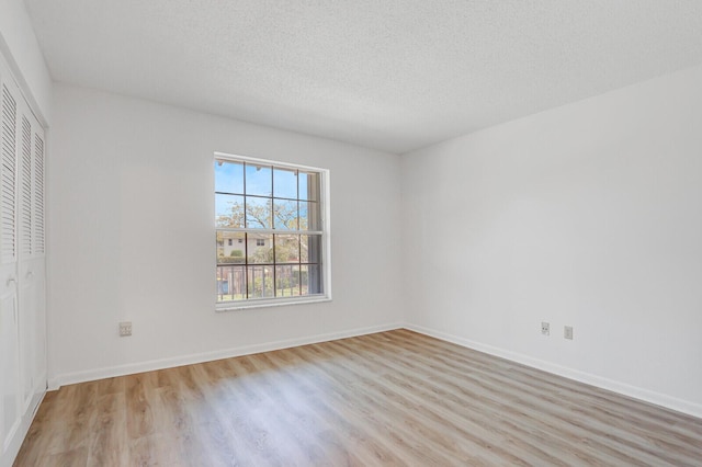 1852 SW Palm City Rd Unit 202, Stuart, FL 34994 - unfurnished bedroom featuring light wood finished floors, a closet, and a textured ceiling