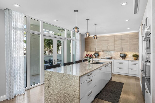 3200 S Ocean Blvd Unit 101, Highland Beach, FL 33487 - kitchen featuring a sink, modern cabinets, backsplash, light wood-style floors, and recessed lighting