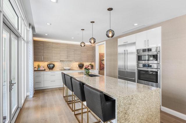 3200 S Ocean Blvd Unit 101, Highland Beach, FL 33487 - kitchen featuring stainless steel appliances, modern cabinets, a sink, decorative backsplash, and recessed lighting