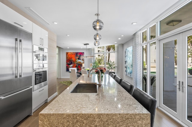 3200 S Ocean Blvd Unit 101, Highland Beach, FL 33487 - kitchen featuring stainless steel appliances, a sink, modern cabinets, light wood-style floors, and white cabinetry