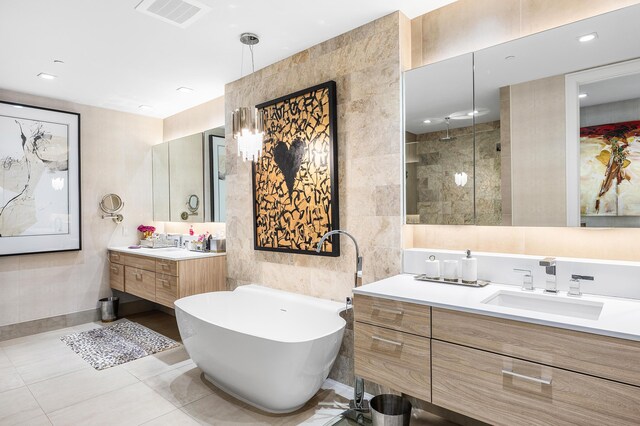 3200 S Ocean Blvd Unit 101, Highland Beach, FL 33487 - bathroom with tile walls, a freestanding tub, two vanities, tile patterned floors, and tiled shower