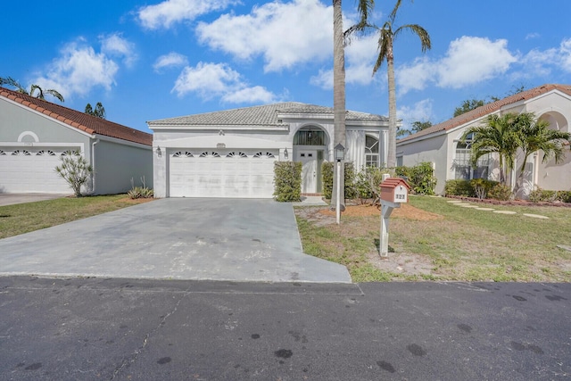 view of front of house with concrete driveway, stucco siding, a tiled roof, and an attached garage