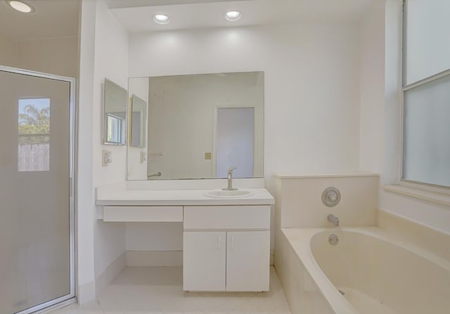bathroom featuring tile patterned floors, a garden tub, and vanity