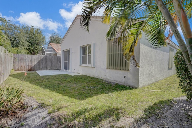 back of property with a fenced backyard, a patio, a lawn, and stucco siding