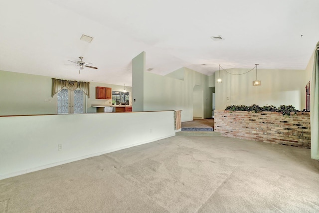 unfurnished living room featuring carpet floors, vaulted ceiling, visible vents, and ceiling fan with notable chandelier