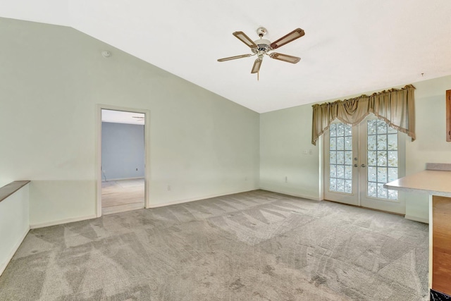 empty room with ceiling fan, french doors, baseboards, lofted ceiling, and carpet