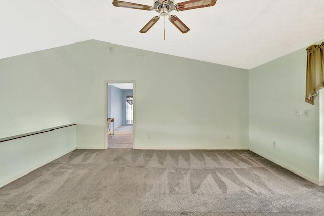 carpeted spare room featuring baseboards, ceiling fan, and vaulted ceiling