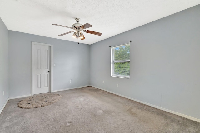 carpeted empty room featuring baseboards and ceiling fan