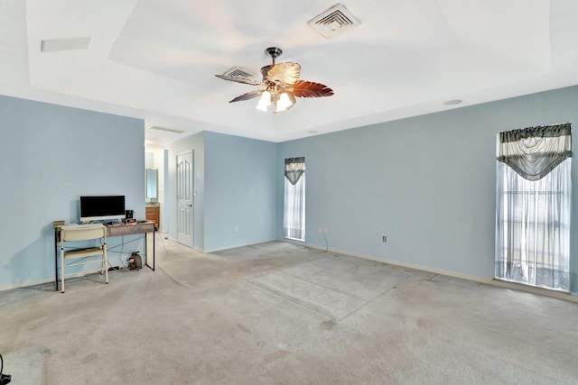 interior space with carpet floors, ceiling fan, visible vents, and a raised ceiling